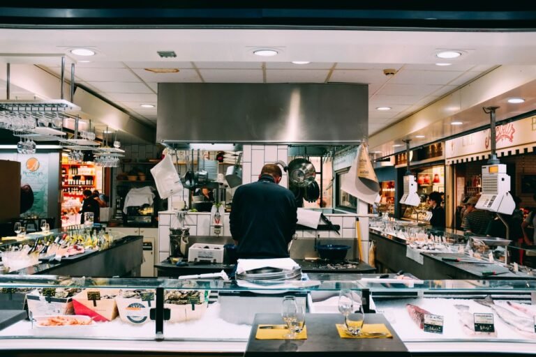 Home Chef preparing fresh seafood in a bustling indoor market setting.