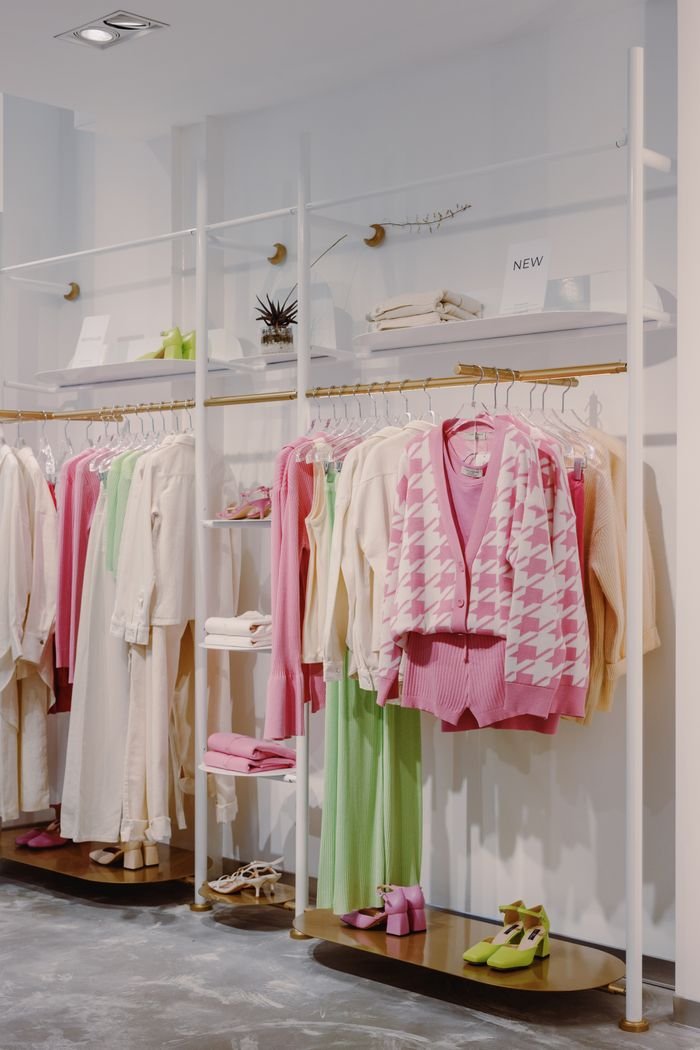 Home Stylish clothing display in modern boutique with colorful outfits and decor.